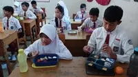 Pelajar di SDN Ciwangi, Kabupaten Purwakarta tengah menyantap bekal makanan dari rumah saat jam istirahat. Ini merupakan salah satu implementasi dari program Pedidikan Berkarakter yang digulirkan pemerintah di wilayah itu. Foto (Liputan6.com/Asep Mulyana).