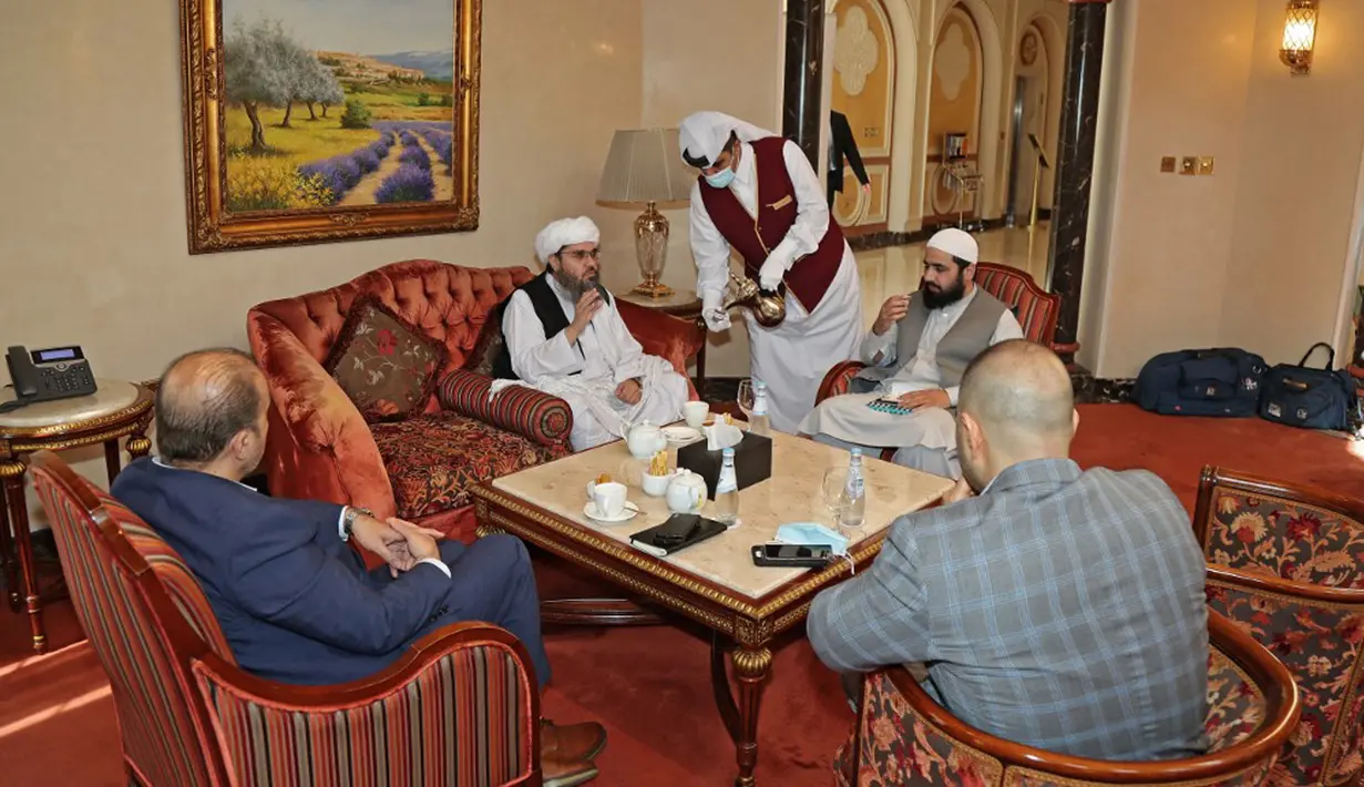 Mantan utusan Taliban untuk Arab Saudi Shahabuddin Delawar (tengah) menyeruput kopi sebelum pertemuan dengan diplomat asing di Doha, Qatar, Selasa (12/10/2021). Taliban mengadakan pembicaraan dengan utusan Uni Eropa dan AS untuk mencari dukungan internasional. (KARIM JAAFAR/AFP)