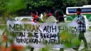 Sebuah spanduk berisi tuntutan mereka tampak dibentangkan dalam aksi unjuk rasa di Bundaran HI Jakarta, Jumat (12/12/2014). (Liputan6.com/Johan Tallo)
