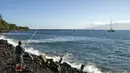 Seorang pria memancing dipinggir pantai di Lahaina, Maui, Hawaii, Rabu (30/7/2015) . Maui adalah pulau terbesar kedua di Hawai yang memiliki pemandangan menakjubkan. (REUTERS/Marco Garcia)