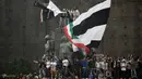 Fans Juventus memanjat monumen kota saat merayakan keberhasilan timnya meraih trofi Serie A di Turin, Italia, (19/5/2018). Juventus meraih gelar Seri A tujuh kali secara beruntun. (AFP/Marco Bertorello)