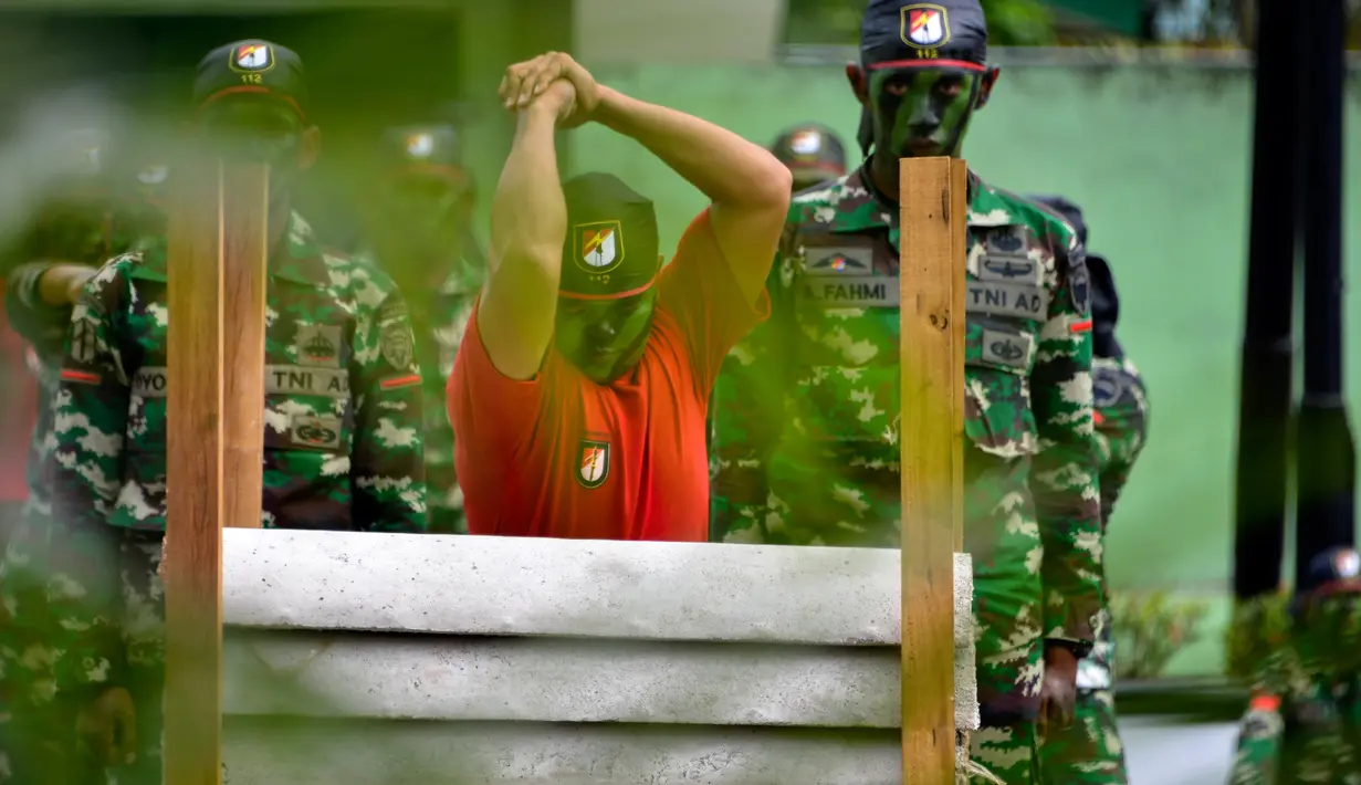Prajurit TNI Yonif Raider 112/Dharma Jaya mencoba mematahkan pipa beton dengan tangannya saat atraksi dalam upacara sertijab di Banda Aceh, Aceh, Rabu (18/9/2019). Mayor Inf Syarifuddin Liwang menjadi Komandan Yonif Raider 112/Dharma Jaya menggantikan Mayor Inf Agus Alfauzi. (CHAIDEER MAHYUDDIN/AFP)
