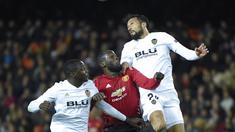 Romelu Lukaku berduel dengan bek Valencia, Ezequiel Garay pada laga terakhir grup H Liga Champions yang berlangsung di stadion Mestalla, Valencia, Rabu (13/12). Manchester United kalah 1-2 atas Valencia. (AFP/Jose Jordan)