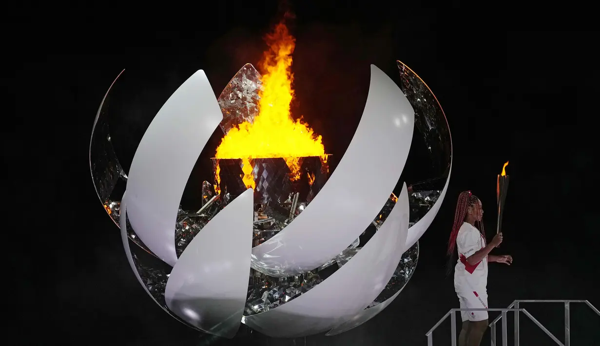 Petenis putri Naomi Osaka menjadi pembawa obor terakhir yang menyulut api Olimpiade ke kaldron. Penyalaan api Olimpiade tersebuti menjadi puncak dari upacara pembukaan Olimpiade Tokyo 2020. (Foto: AP/David J. Phillip)
