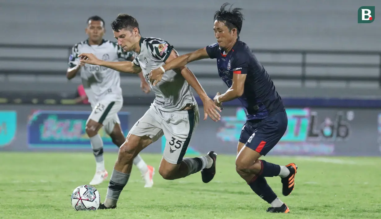 Pemain Persikabo 1973, Pushniakou Siarhei (kiri) berebut bola dengan pemain Arema FC, Rensi Yamaguchi dalam laga tunda pekan ke-17 BRI Liga 1 2021/2022 di Stadion I Wayan Dipta, Gianyar, Bali, Rabu (5/1/2022). (Bola.com/Nandang Permana)