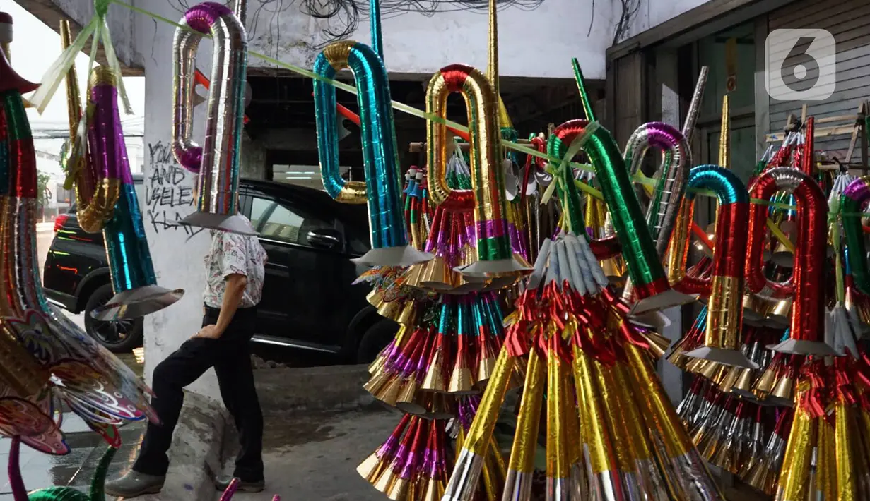 Penjual terompet menjajakan dagangannya di kawasan Glodok, Jakarta, Jumat (27/12/2019). Menjelang perayaan Tahun Baru 2020, penjual terompet musiman mulai marak di sejumah kawasan dengan harga jual berkisar Rp5ribu hingga Rp15ribu tergantung model. (Liputan6.com/Immanuel Antonius)