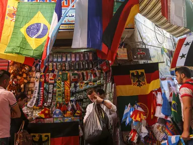 Sejumlah pembeli mencari pernak-pernik negara yang berpartisipasi pada Piala Dunia FIFA 2018 di jalan pasar di kota tua Damasku, Suriah (6/6). Piala Dunia akan digelar pada 14 Juni 2018 di Rusia. (AFP Photo/Louai Beshara)