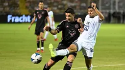 Pemain Inter Miami, Luis Suarez (kiri) berebut bola dengan pemain Timnas El Salvador, Jorge Cruz pada laga persahabatan yang digelar di Kota San Salvador, El Salvador, Sabtu (20/01/2024) pagi WIB. (AFP/Marvin Recinos)