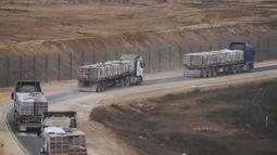 Truk-truk yang mengangkut bantuan kemanusiaan untuk warga Palestina di Gaza bergerak di sepanjang perbatasan dengan Jalur Gaza di selatan Israel, Rabu 13 Agustus 2025. (AP Photo/Ariel Schalit)
