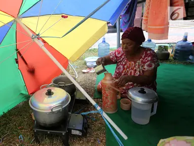 Pengungsi korban gempa dan tsunami Palu menuang air di tenda pengungsian lapanga Walikota Palu, Sulteng, Senin (8/10). Pemerintah akan membangun barak pengungsian bagi korban gempa dan tsunami di Kota Palu, Sigi dan Donggala. (Liputan6.com/Fery Pradolo)