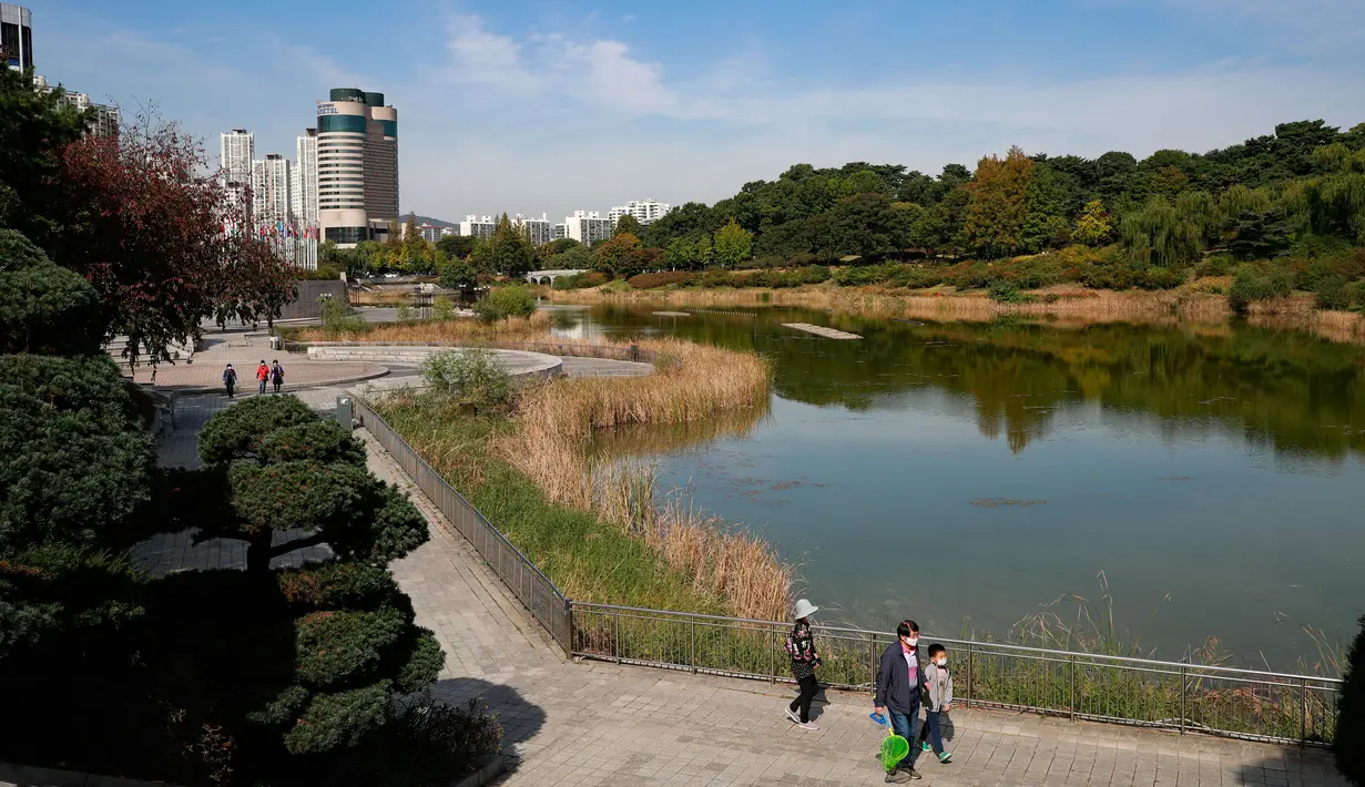 Orang-orang menikmati hari musim gugur yang hangat di Taman Olimpiade di Seoul, Korea Selatan (15/10/2020). Banyak warga memilih datang ke taman-taman publik untuk melakukan aktivitas luar ruangan di tengah musim gugur. (Xinhua/Wang Jingqiang)