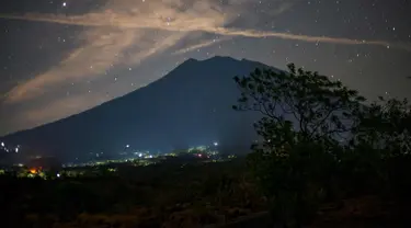 Pemandangan malam Gunung Agung di bawah langit penuh bintang terlihat dari Kubu di Karangasem, Bali, (28/9). Gunung Agung sejak sepekan lalu masih bertahan dengan status awas atau Level IV. (AFP Photo/Bay Ismoyo)