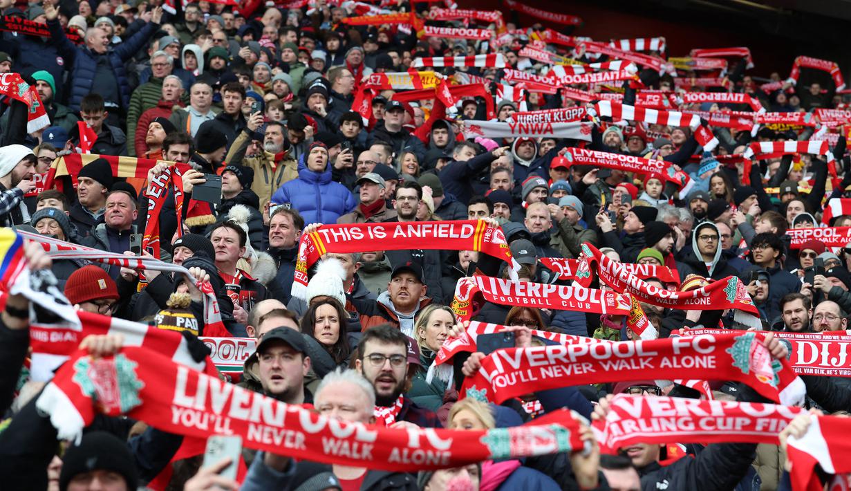 Para suporter Liverpool membentangkan syal saat mendukung timnya dalam laga lanjutan Liga Inggris 2024/2025 melawan Wolverhampton di Anfield, Liverpool, Inggris, Minggu (16/02/2025). (AFP/Darren Staples)