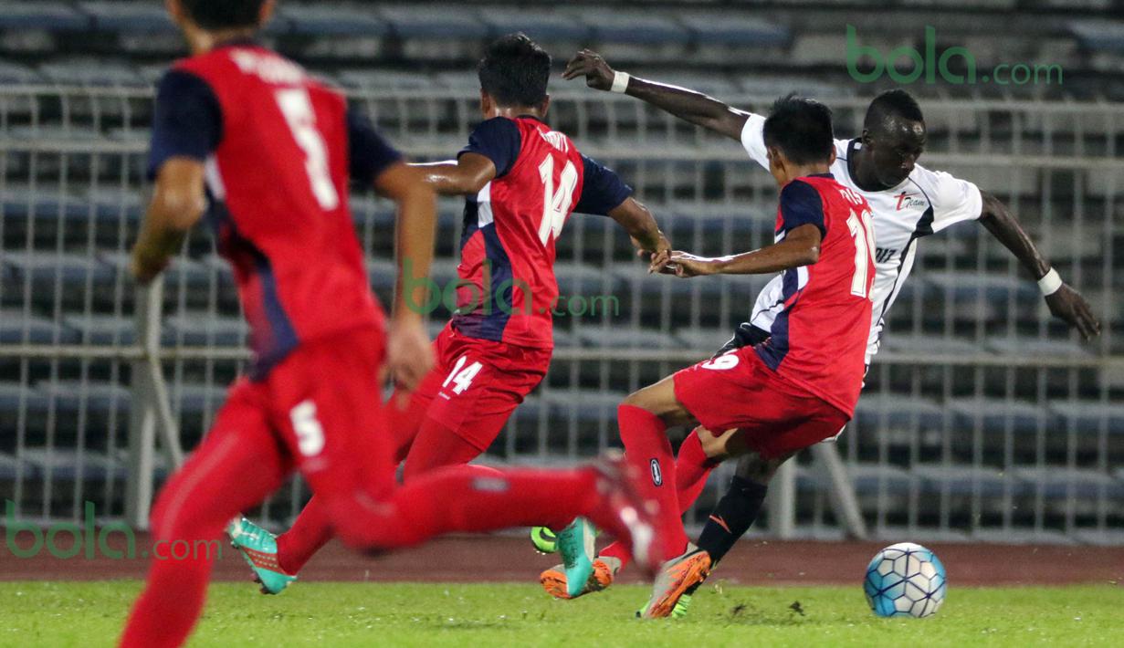 Gelandang T-Team Malaysia, Makan Konate, dihadang pemain ATM FA pada laga play-off Malaysia Super League 2016. (Bola.com/Nicklas Hanoatubun)