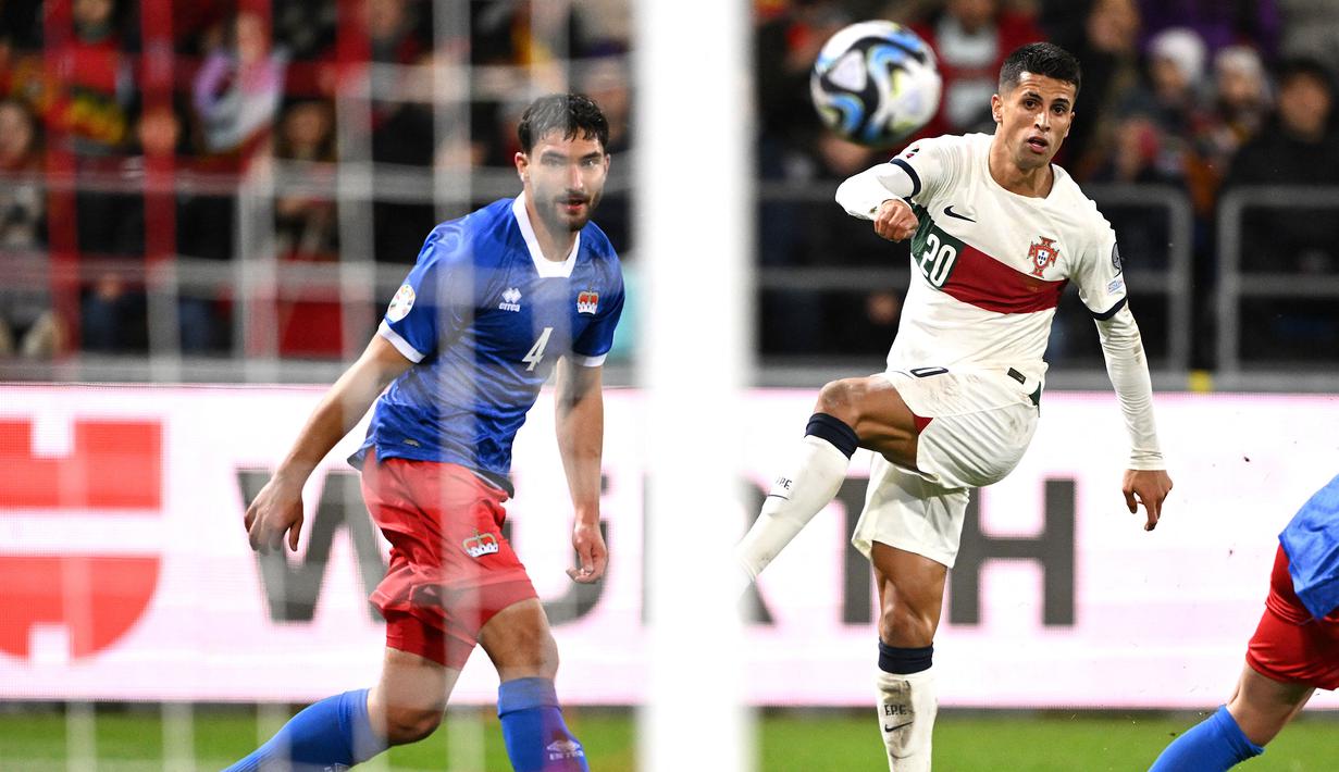 Bek Timnas Portugal, Joao Cancelo (kanan) melepaskan tendangan yang menghasilkan gol kedua ke gawang Liechtenstein pada laga lanjutan Grup J Kualifikasi Euro 2024 di Rheinpark Stadium, Vaduz, Jumat (17/11/2023) dini hari WIB. (AFP/Sebastien Bozon)
