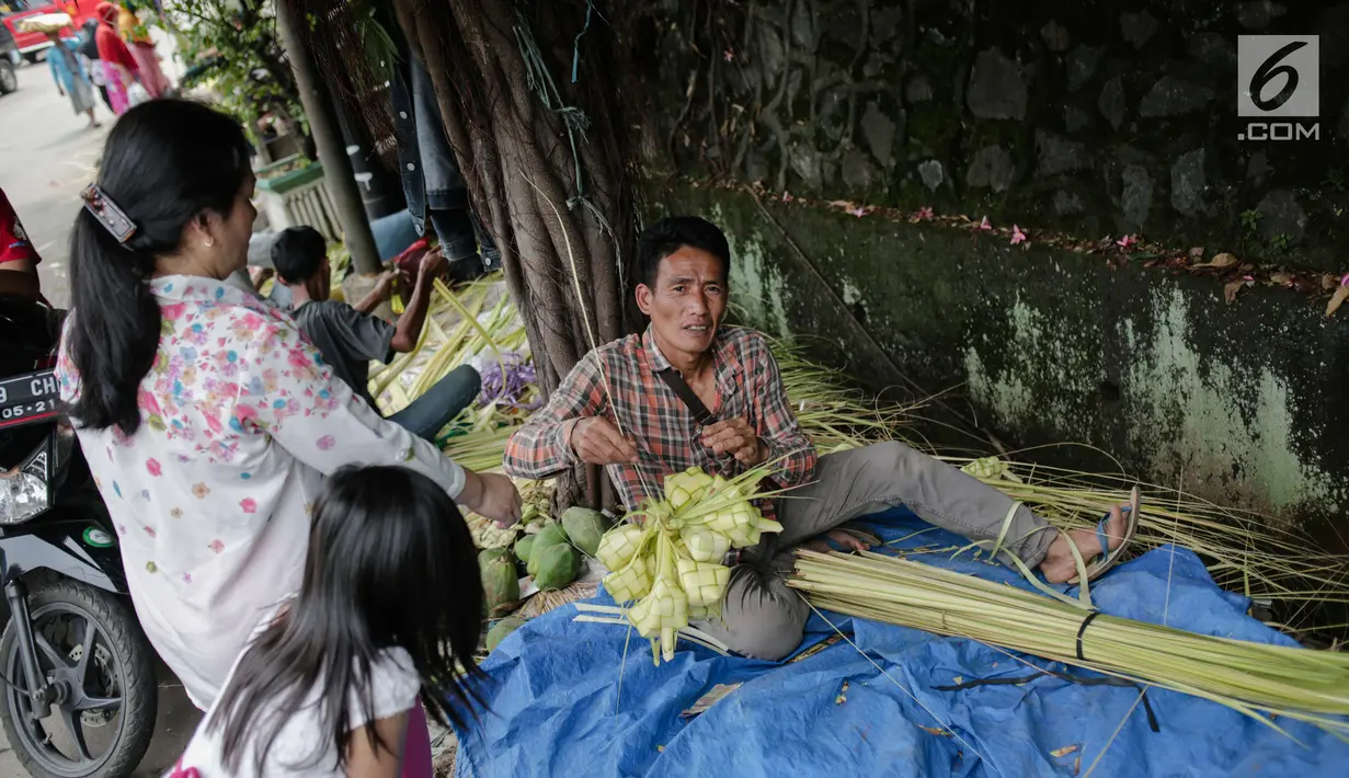 Pedagang melayani pembeli kulit ketupat di Pasar Palmerah, Jakarta, Senin (2/6/2019). Jelang lebaran penjualan kulit ketupat mulai ramai, omsetnya melonjak hingga 10 kali lipat. (Liputan6.com/Faizal Fanai)
