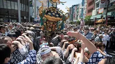 Para peserta membawa kuil portabel atau "Mikoshi" pada Festival Sanja Matsuri di luar kuil Sensoji, Tokyo, Minggu (20/5). Sanja Matsuri adalah festival tahunan di distrik Asakusa yang diadakan pada akhir pekan ketiga pada bulan Mei. (AFP/Behrouz MEHRI)