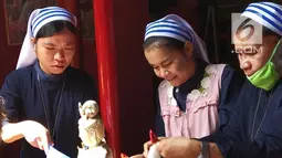 Suster Katolik dan pengurus vihara membersihkan patung dewa dewi di Vihara Kwan In Thang, Pondok Cabe, Tangerang Selatan, Rabu (30/1). Dalam pembersihan itu melibatkan umat agama lain sebagai bentuk toleransi kerukunan beragama. (Merdeka.com/Arie Basuki)