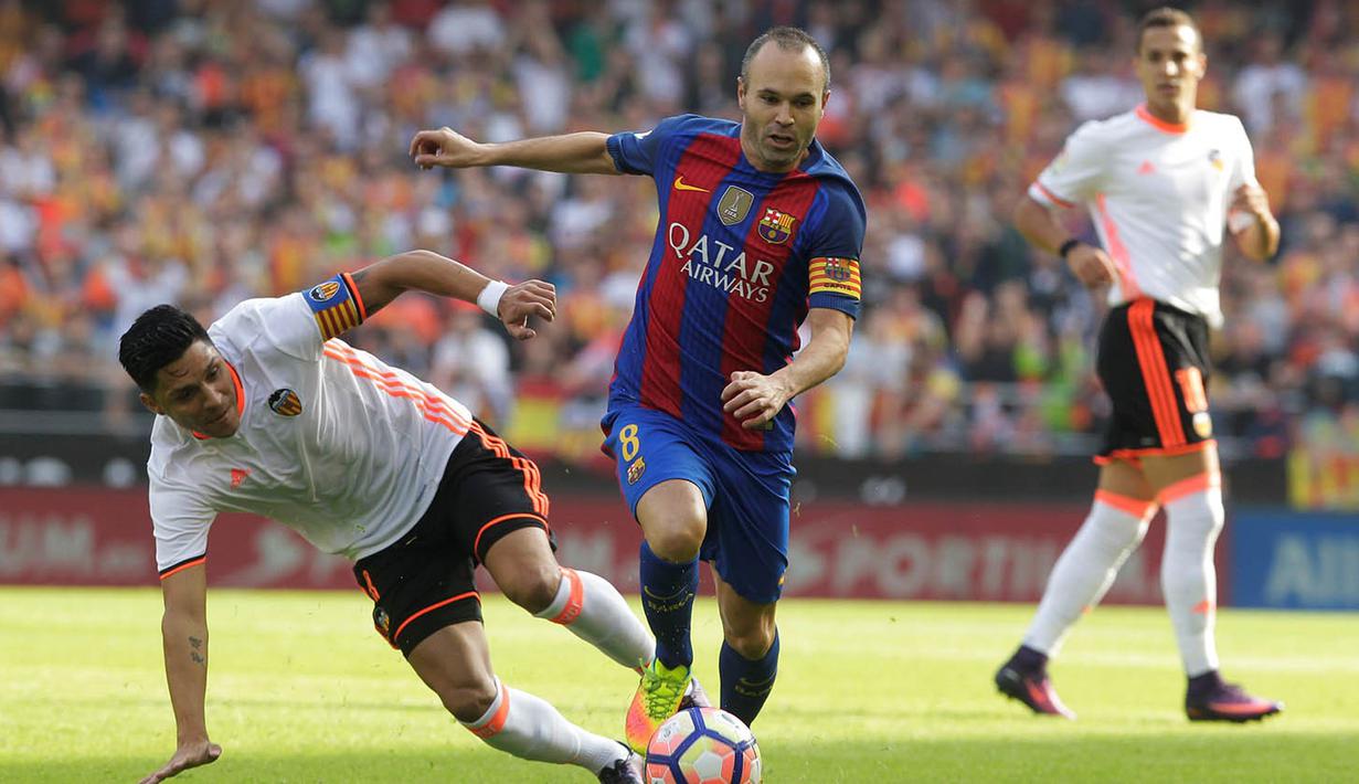 Gelandang Barcelona, Andres Iniesta, melewati hadangan gelandang Valencia, Enzo Perez, pada laga La Liga di Stadion Mestalla, Valencia, Sabtu (22/10/2016). Barcelona menang 3-2 atas Valencia. (Reuters/Heino Kalis)