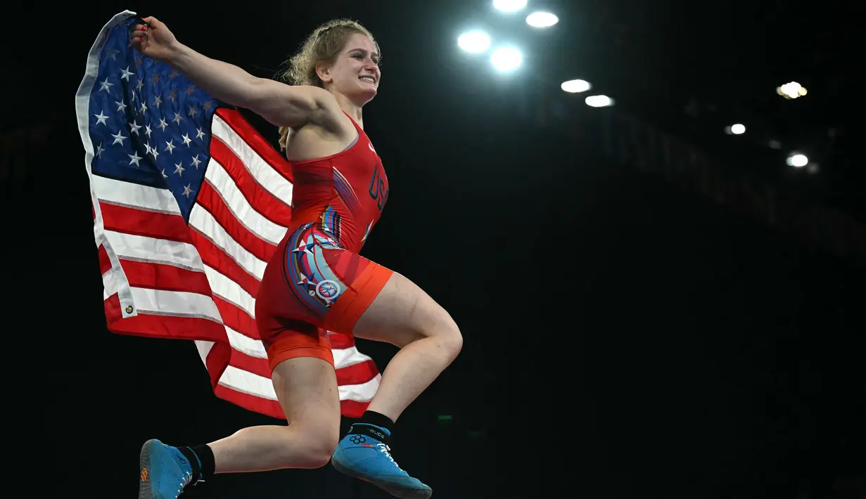 Pegulat Amerika Amit Elor berselebrasi dengan bendera nasionalnya setelah mengalahkan Meerim Zhumanazarova dari Kirgistan pada final gulat nomor freestyle 68kg putri Olimpiade Paris 2024 di Champ-de-Mars Arena, Selasa (6/8/2024). (Punit PARANJPE / AFP)