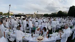 Orang-orang berpakaian putih berkumpul bersiap untuk makan malam bersama atau "Diner en Blanc" yang ke-30 di Paris, Prancis (3/6). Tempat dilaksanakannya acara ini akan dirahasiakan oleh penyelenggara hingga 2-1 jam sebelum dimulai. (AFP/Francois Guillot)