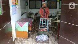 Petugas memindahkan barang-barang saat membersihkan ruangan di MTsN 19 Pondok Labu, Jakarta, Jumat (7/10/2022). Petugas PPSU, Satpol PP, dan Dinas Pemadam Kebakaran membersihkan ruang kelas, kantin, dan fasilitas lainnya usai terendam banjir pada Kamis sore kemarin. (Liputan6.com/Herman Zakharia)