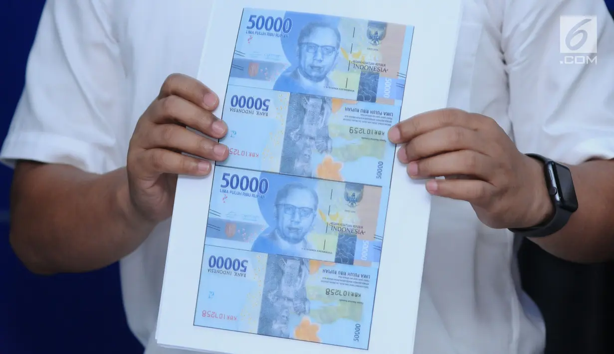 Petugas menunjukkan hasil cetak uang palsu Rp 50.000,- emisi 2016 saat rilis di Bareskrim Mabes Polri, Jakarta, Senin (29/1). Dirtidpid Ekonomi dan Khusus Bareskrim Polri menangkap empat tersangka di wilayah Cikarang. (Liputan6.com/Helmi Fithriansyah)
