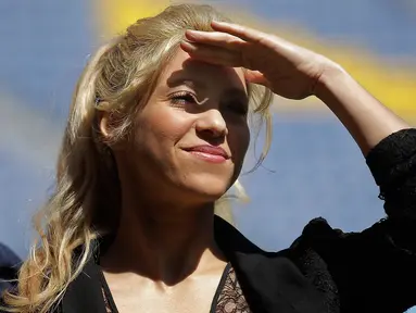 Penyanyi Kolombia, Shakira berdiri di bawah terik matahari saat menghadiri acara amal di Stadion Camp Nou di Barcelona, Selasa (28/3). Shakira akan membangun sekolah bekerja sama dengan klub Barcelona dan Yayasan La Caixa.(AP Photo/Manu Fernandez)