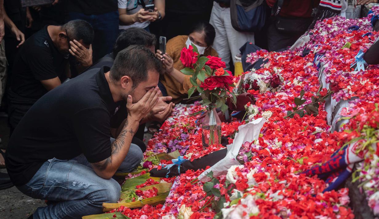 Mereka juga berdoa usai melakukan tabur bunga di Tugu Singa Stadion Kanjuruhan. (AFP/Juni Kriswanto)