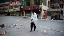 Warga berjalan-jalan setelah tidur di luar rumahnya di Zhangzha, provinsi Sichuan, China barat daya, Kamis (10/8). Ratusan warga memilih menghabiskan malam di luar rumah usai terjadinya gempa 6,5 SR yang menewaskan belasan orang (Nicolas ASFOURI/AFP)