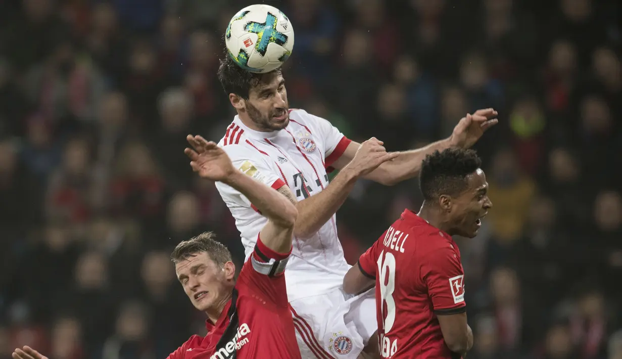 Pemain Bayern Munchen, Javi Martinez (tengah) menghalau bola dari kejaran dua pemain Laverkusen  pada lanjutan Budesliga di Bay Arena, Laverkusen, (12/1/2018). Bayern Munchen menang 3-1. (Bernd Thissen/dpa via AP)