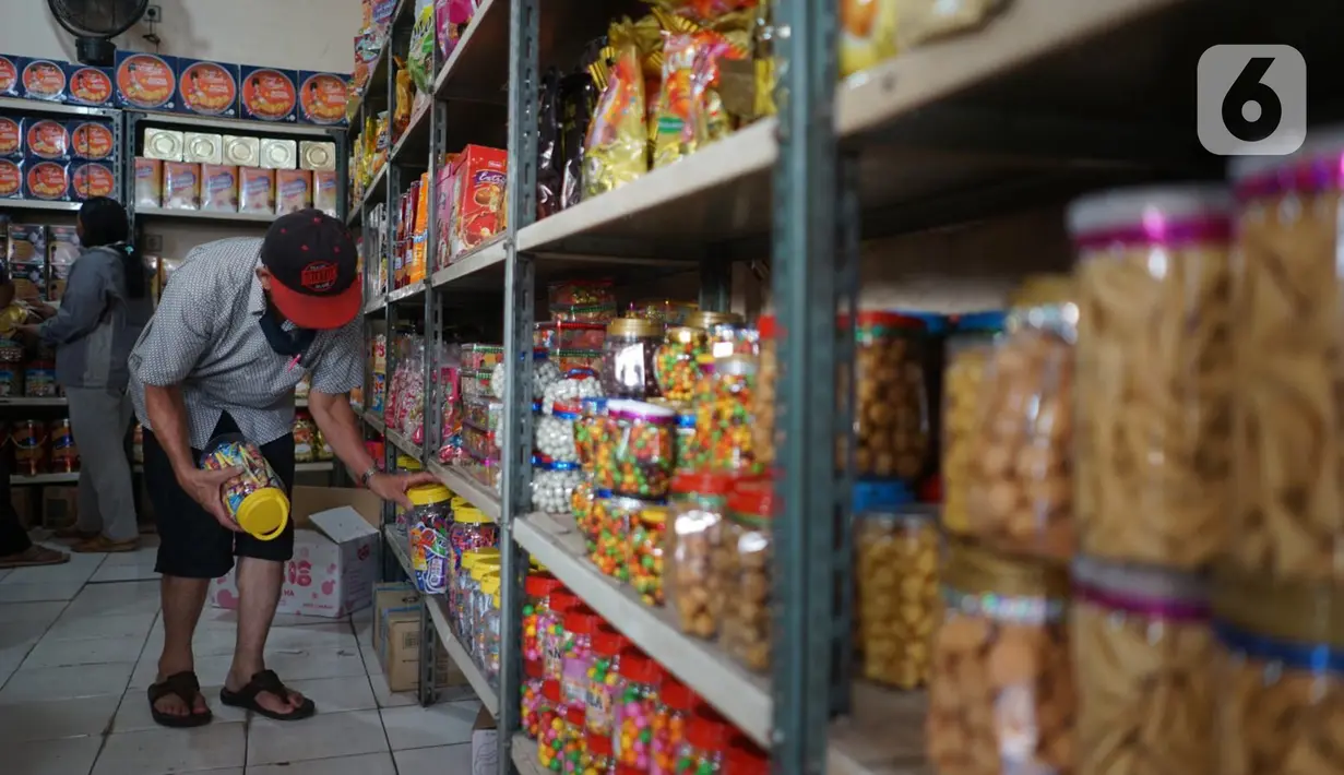 Pembeli melihat dagangan kue kering di salah satu toko penjualan kue kering di kawasan Ciracas, Jakarta, Selasa (19/5/2020). Adanya pandemi covid-19 diakui para pedagang menyebabkan penjualan kue kering menjelang lebaran turun hingga 50 persen. (Liputan6.com/Immanuel Antonius)