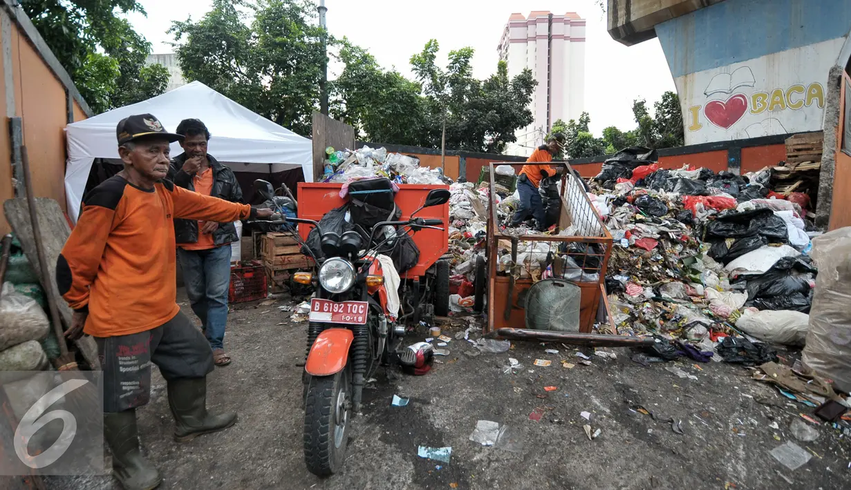 Sejumlah petugas kebersihan dengan kendaraan angkutnya mengumpulkan sampah di tempat pembuangan sampah sementara (TPSS), Pasar Baru, Jakarta, Jumat (25/11). Dalam sehari, Kelurahan Pasar Baru menghasilkan sampah mencapai 3 ton. (Liputan6.com/Yoppy Renato)