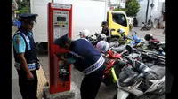 Petugas tengah mempersiapkan mesin pembayaran Teminal Parkir Elektronik (TPE) di Jalan Sabang, Jakarta, Kamis (29-01-2015).  Sebanyak enam bank terlibat dalam sistem pembayaran ini. (Liputan6.com/Andrian M Tunay)
