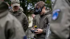 Seorang mahasiswa bernama Bartosz Ladocha mengenakan kacamata khusus untuk mengendalikan drone FPV (first-person-view) saat mengikuti kursus drone di Sekolah Militer, Legnica, Polandia Barat, pada 8 Oktober 2025. (Wojtek RADWANSKI/AFP)