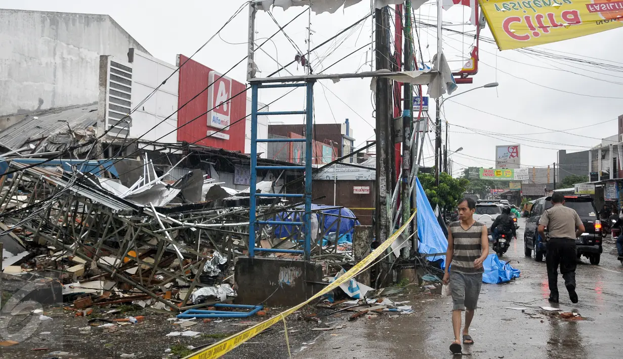 Warga melintas di depan outlet Pizza Hut Delivery (PHD) Jatimelati, Bekasi, yang hancur akibat sebuah ledakan, Minggu (23/10). Akibat ledakan itu, bangunan Alfamidi yang berada di samping PHD ikut hancur dan berantakan. (Liputan6.com/Yoppy Renato)