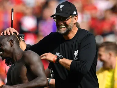 Manajer Liverpool Jurgen Klopp (kanan) memegang kepala Sadio Mane usai tim asuhannya mengalahkan Newcastle United pada laga Liga Inggris di Anfield, Liverpool, Inggris, Sabtu (14/9/2019). Sadio Mane dan Mohamed Salah membawa Liverpool menghajar Newcastle 3-1. (Paul ELLIS/AFP)