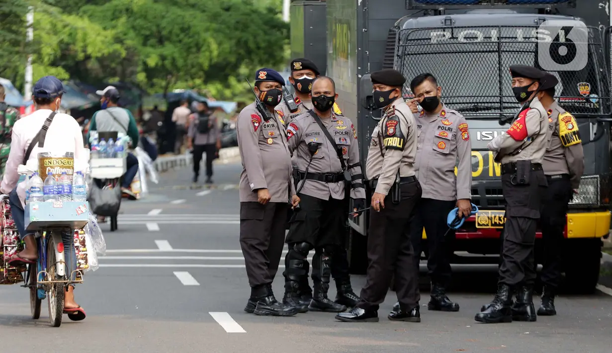 Petugas kepolisian bersiaga di jalan Kuningan Persada sekitar Gedung Merah Putih KPK, Jakarta, Selasa (1/6/2021). Pengamanan gedung KPK dan sekitarnya diperketat terkait upacara pelantikan pegawai KPK menjadi Aparatur Sipil Negara. (Liputan6.com/Helmi Fithriansyah)