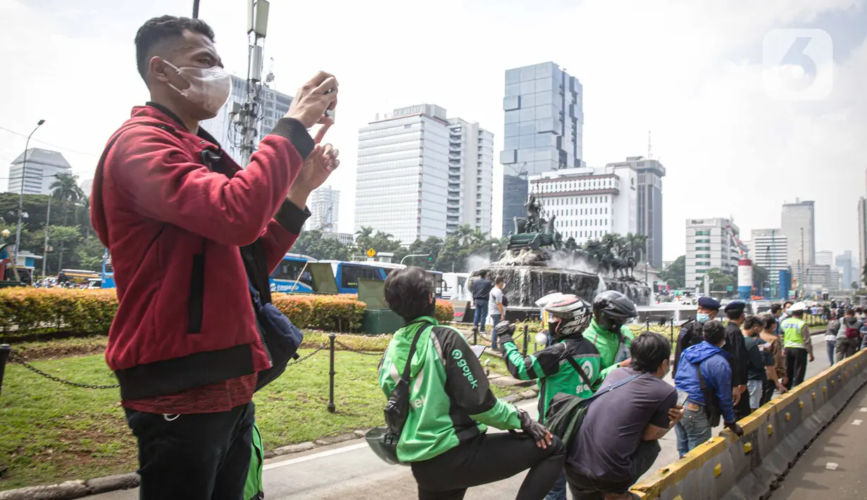 Antusias warga menyaksikan parade pembalap MotoGP di kawasan Jakarta, Rabu (16/3/2022).  Gelaran parade MotoGP di Jakarta dalam rangka penyambutan event MotoGP Mandalika 2022. (Liputan6.com/Faizal Fanani)