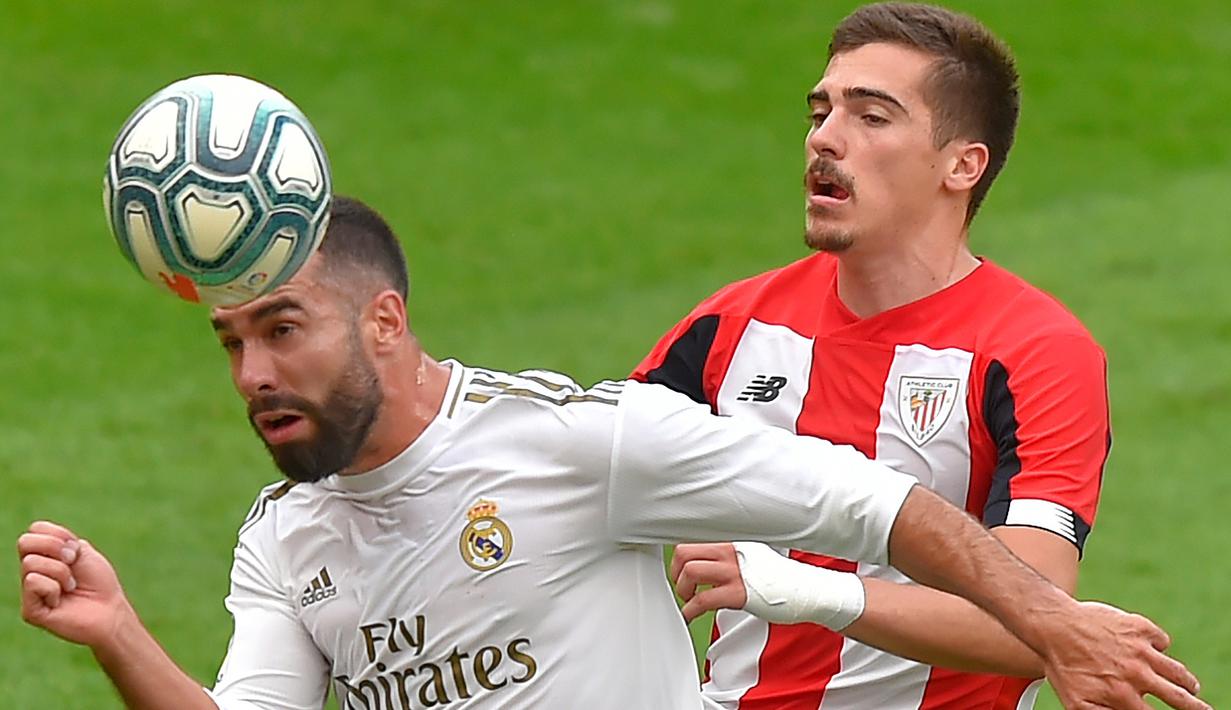 Bek Real Madrid, Daniel Carvajal, duel udara dengan pemain Athletic Bilbao, Inigo Cordoba, pada laga La liga di Stadion San Mames, Minggu (5/7/2020). Real Madrid menang 1-0 atas Athletic Bilbao. (AFP/Ander Gillenea)
