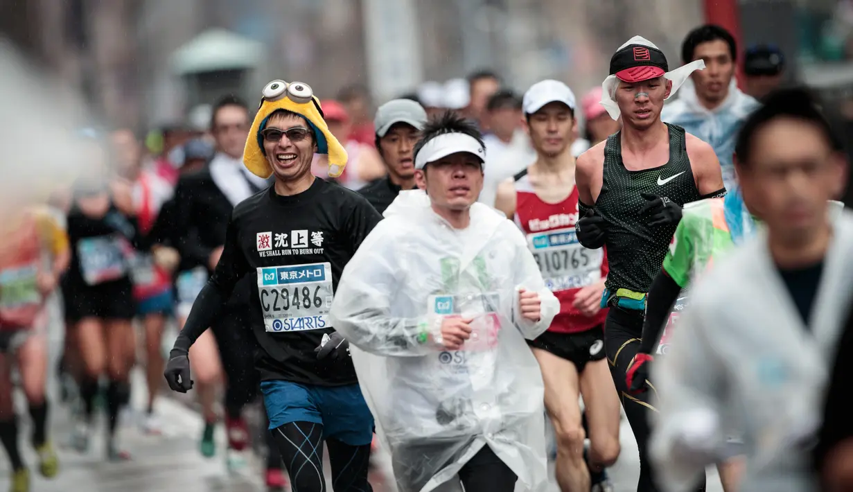 Seorang peserta mengenakan topi karakter Minion saat berlari selama Tokyo Marathon 2019 di Jepang, Minggu (3/3). Sebagian peserta tampil dengan mengenakan kostum unik seperti tokoh kartun. (AFP Photo/Behrouz Mehri)