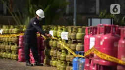 Petugas memasang garis polisi di dekat tabung LPG bersubsidi  di Jakarta, Jumat (15/7/2022). Direktorat Tindak Pidana Tertentu (Dirtipidter) Bareskrim Polri menggelar perkara kasus penyalahgunaan LPG bersubsidi dengan cara menyuntikkan gas 3 kilogram bersubsidi ke tabung gas ukuran 5,5 kilogram, 12 kilogram, dan 50 kilogram. (merdeka.com/Imam Buhori)