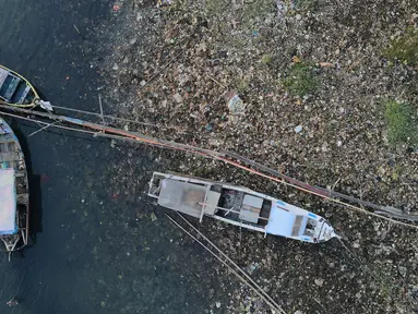 Foto udara menunjukkan sampah mengendap di muara Kanal Banjir Timur, Marunda Kepu, Cilincing, Jakarta Utara, Jakarta, Selasa (2/5/2023). Sampah berasal dari Kanal Banjir Timur dan Teluk Jakarta yang terbawa angin barat. (merdeka.com/Imam Buhori)