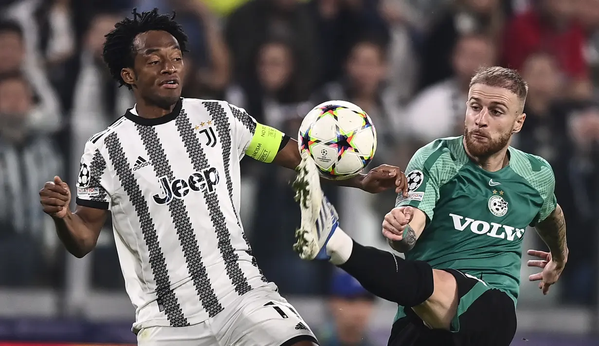 Gelandang Juventus Juan Cuadrado berebut bola dengan bek Maccabi Haifa Pierre Cornud pada matchday ketiga Grup H Liga Champions di Allianz Stadium, Kamis (6/10/2022) dini hari WIB.  Juventus berhasil menuntaskan laga dengan kemenangan 3-1. (Fabio Ferrari/LaPresse via AP)