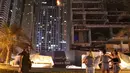 Sejumlah orang mengamati kobaran api yang melalap sebuah gedung pencakar langit Menara Torch, di Dubai, Uni Emirat Arab, Jumat (4/8). Belum jelas apa yang menyebabkan kebakaran di salah satu gedung tertinggi di dunia tersebut. (AFP PHOTO / KARIM SAHIB)