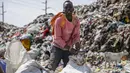 Mohamed Nassur, 17, mengais besi tua untuk dijual di TPA terbesar di Kenya, tempat dia sekarang bekerja setelah ibunya kehilangan pekerjaan dan sekolahnya ditutup karena pandemi virus corona, di Nairobi, Kenya, 26 September 2020. (AP Photo/Brian Inganga)