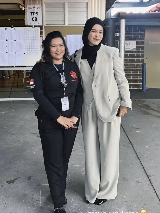 Ana Octarina tampil dengan setelan jas warna putih gading, dari blazer, inner vest, dan celana panjang dipadukan kerudung hitam. [@alifahzarrina]