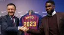 Bek asal Prancis, Samuel Umtiti dan Presiden Barcelona Josep Maria Bartomeu bersalaman pada pengumuman perpanjangan kontraknya di stadion Camp Nou, Senin (4/6). Umtiti secara resmi memperpanjang kontrak dengan Barcelona hingga 2023. (AP/Manu Fernandez)