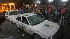Massa melihat dua mobil milik sebuah stasiun TV yang rusak dalam unjuk rasa kenaikan harga BBM di Monterrey, Meksiko, Kamis (5/1). Unjuk rasa tersebut merupakan protes atas kenaikan harga BBM hingga 20% yang dilakukan pemerintah. (Julio Cesar Aguilar/AFP)