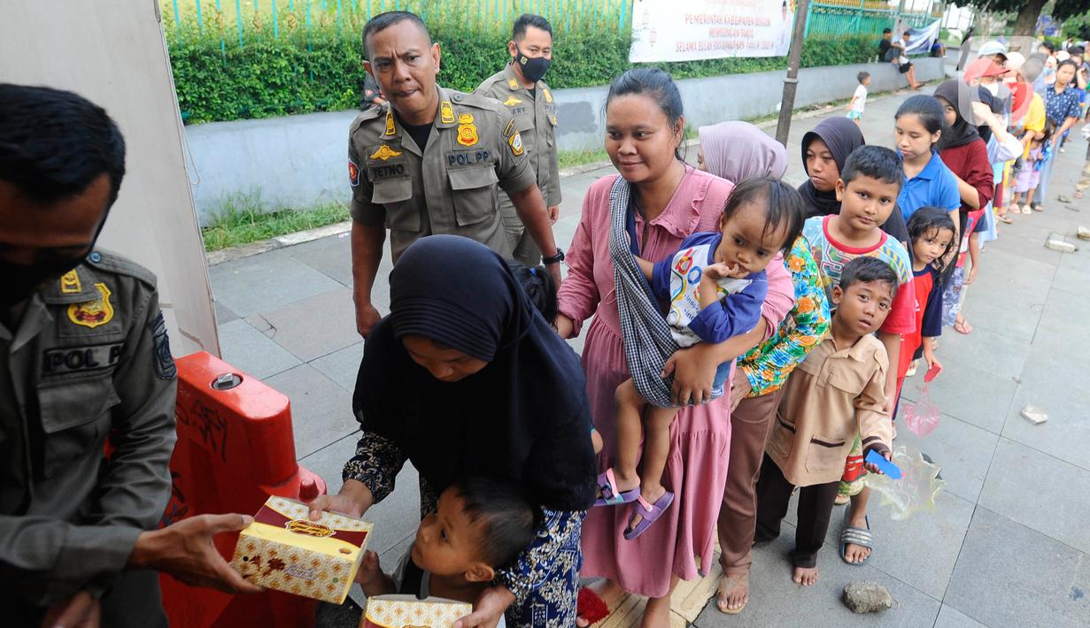 Warga antre untuk mendapatkan takjil di Jalan Raya Tegar Beriman, Cibinong, Kabupaten Bogor, Jawa Barat, Kamis (30/3/2023). (merdeka.com/Arie Basuki)